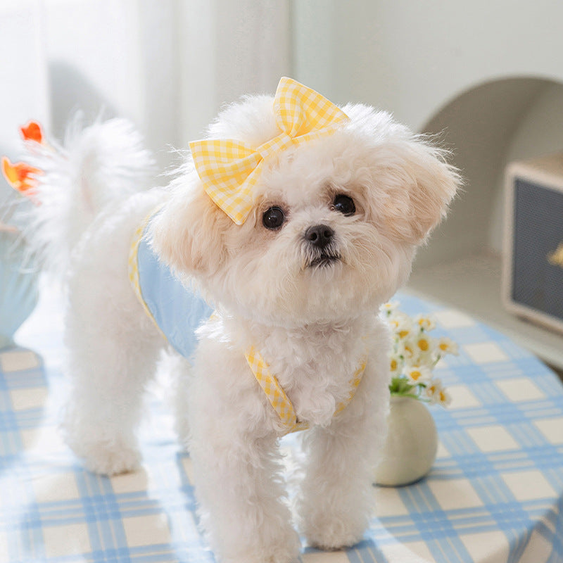 Charming small dog wearing a textured heart salopette and a yellow bow, set in a cozy indoor environment.